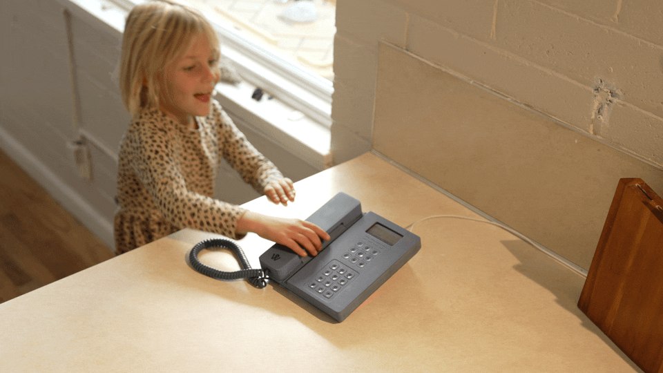 a GIF of a kid picking up a blue WiFi home phone