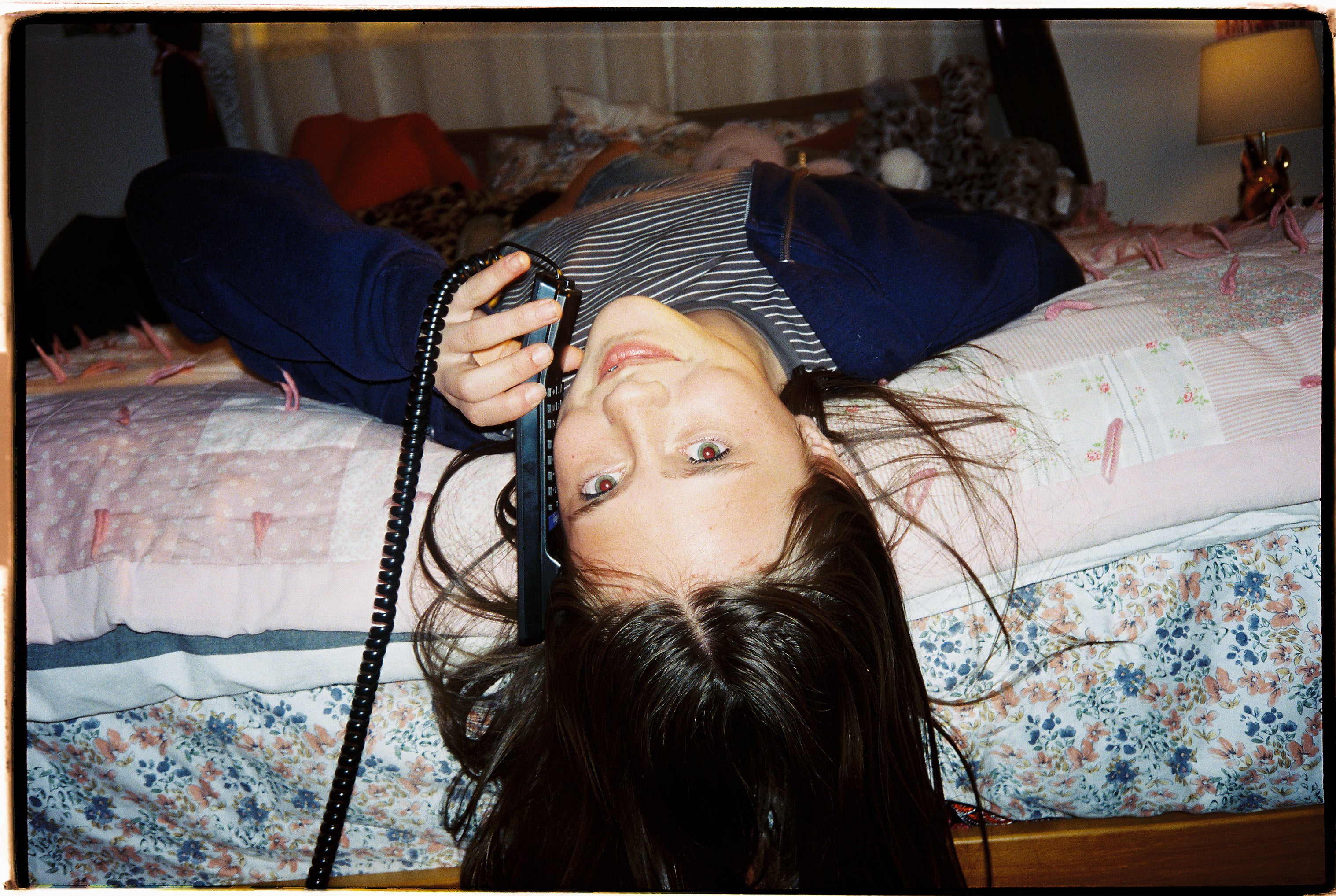 WiFi home phones for kids & families. A girl laying on a bed talking on the phone.